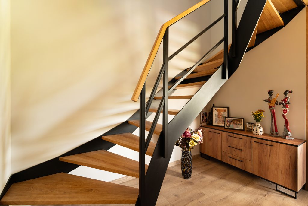 Schody z drewnianymi stopniami i metalową balustradą – ujęcie z innej strony