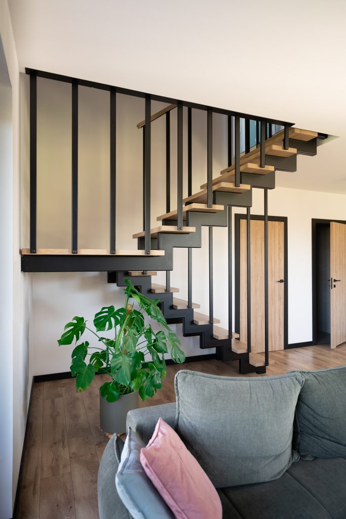 Schody w aranżacji salonu – ujęcie z sofą
